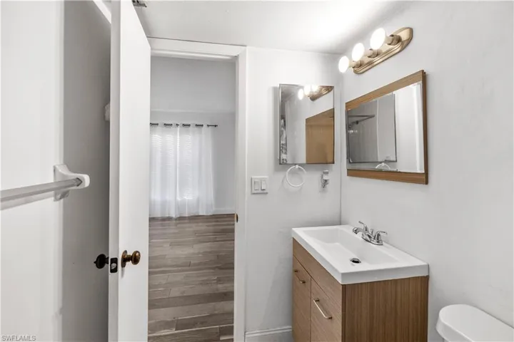 Half bath featuring vanity and wood finished floors