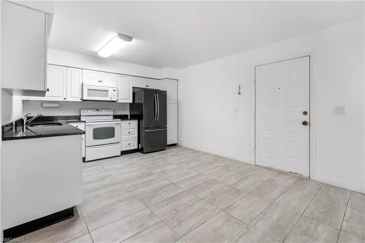 Kitchen with white appliances and white cabinetry