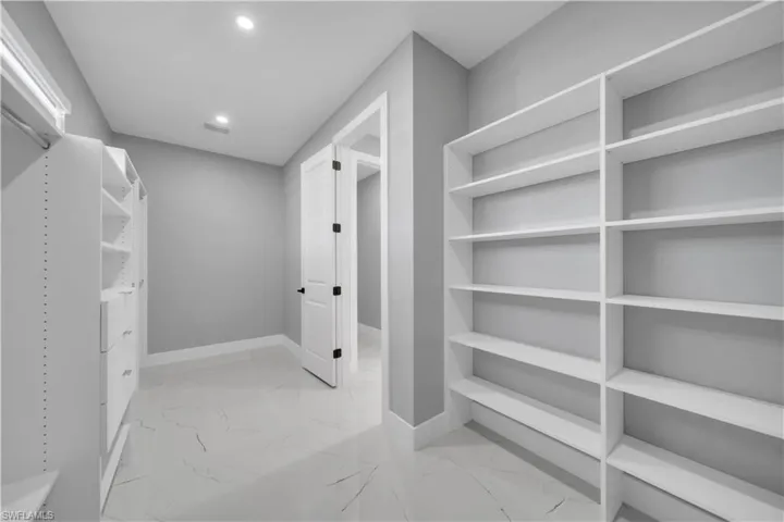 Walk in closet with light marble finish floors