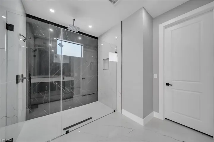 Full bath featuring marble finish floors, a marble finish shower, and recessed lighting