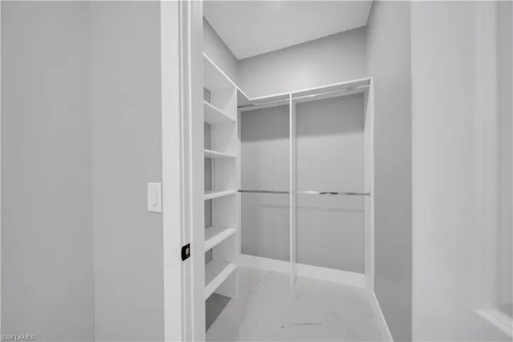 Walk in closet with light marble finish flooring