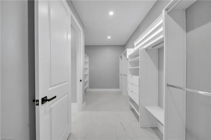 Spacious closet with light marble finish floors