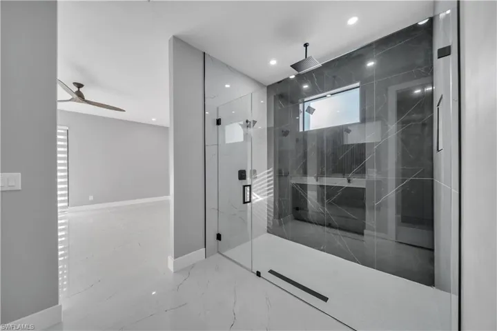 Full bath featuring a marble finish shower, light marble finish floors, a ceiling fan, and recessed lighting