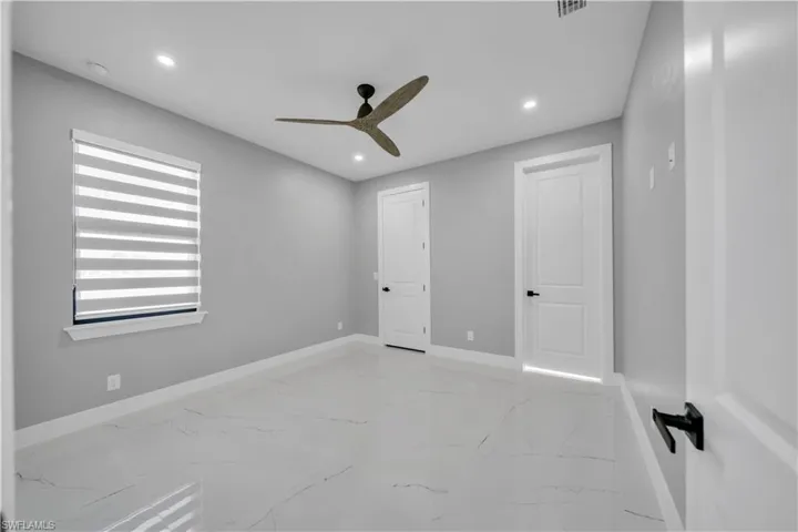 Unfurnished bedroom with recessed lighting, light marble finish flooring, and ceiling fan