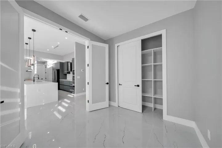 Unfurnished bedroom with light marble finish floors, a closet, and recessed lighting
