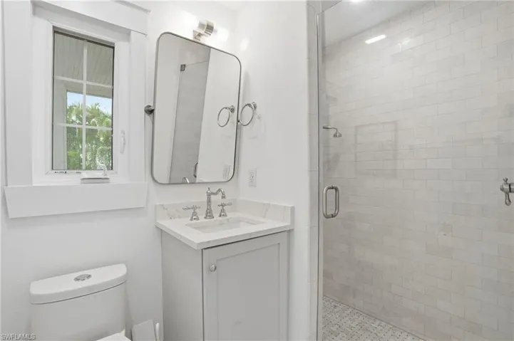 Full bath with a shower stall and vanity