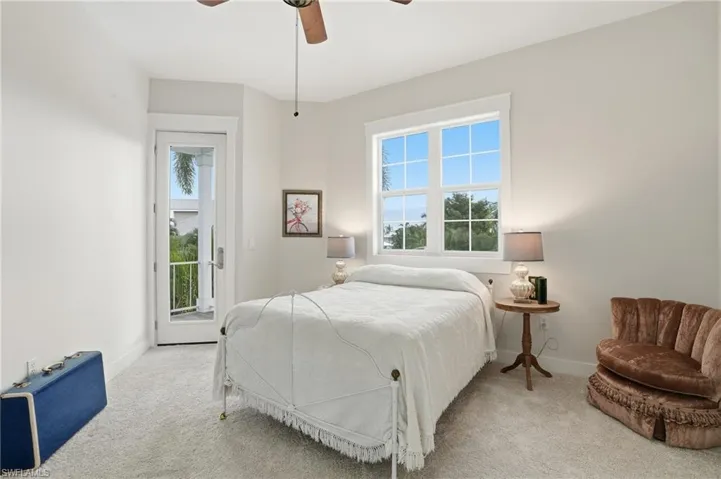 Carpeted bedroom with access to outside and a ceiling fan