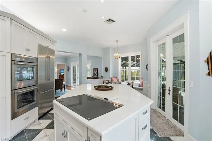 Kitchen with white cabinetry, french doors, a kitchen island, stainless steel appliances, and recessed lighting
