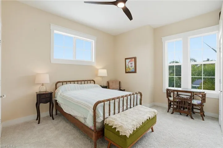 Carpeted bedroom featuring ceiling fan and baseboards