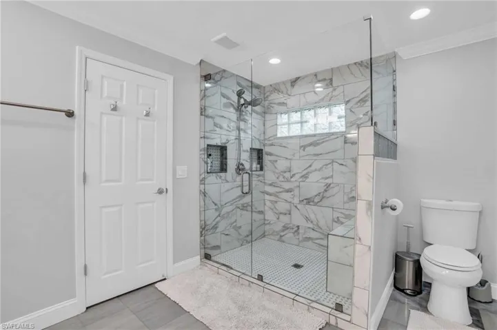 Bathroom with beautifully tiled, walk in shower with built-in bench.