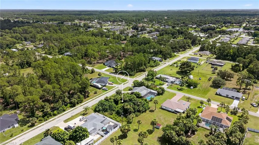 Aerial view of property and surrounding area with nearby suburban area