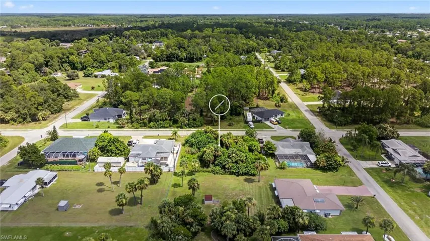 Aerial view of property and surrounding area featuring nearby suburban area