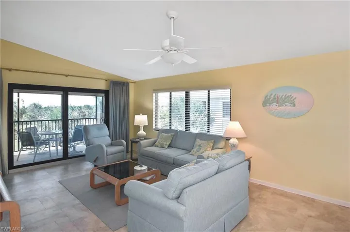 Living area with plenty of natural light, lofted ceiling, and a ceiling fan