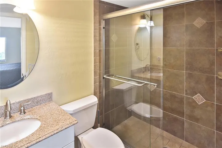 Full bathroom with a shower stall, vanity, and a textured wall
