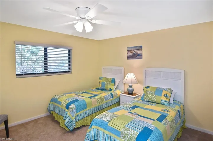 Carpeted bedroom featuring baseboards and ceiling fan