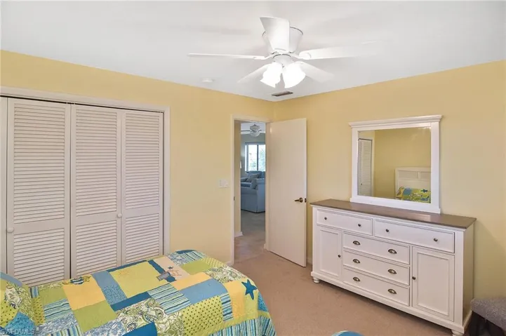 Bedroom featuring light carpet, a closet, and a ceiling fan