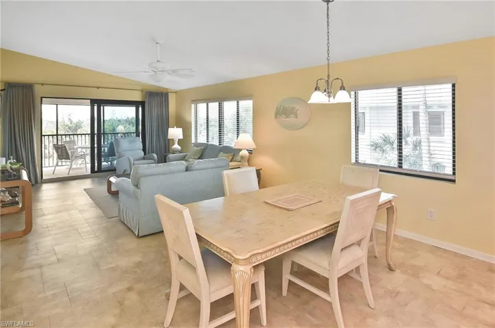 Dining area with lofted ceiling, plenty of natural light, a ceiling fan, and a chandelier