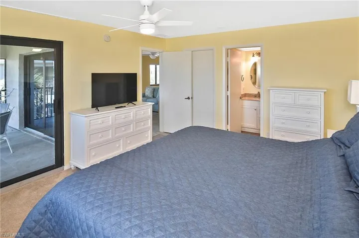 Bedroom with access to exterior, light carpet, and a ceiling fan