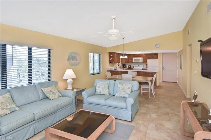 Living area with lofted ceiling and a ceiling fan