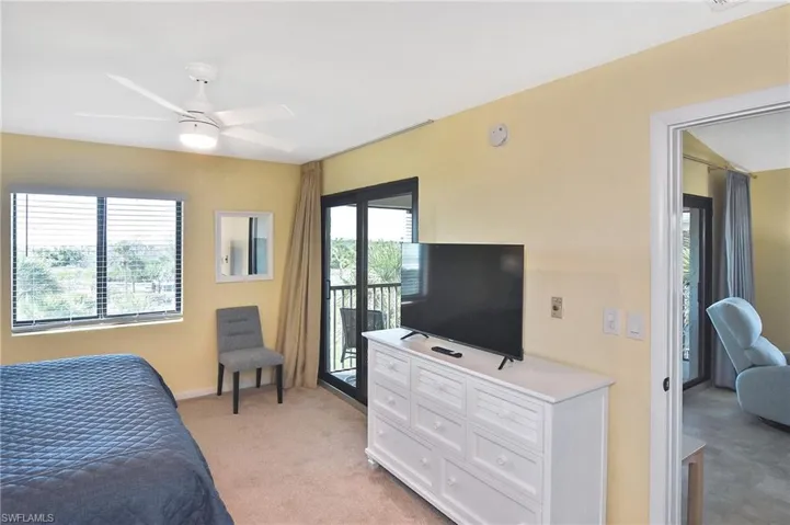Bedroom with light carpet, access to exterior, and ceiling fan