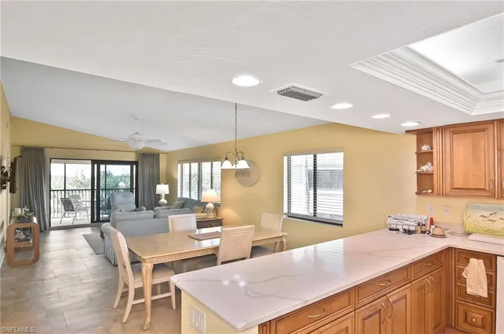 Kitchen featuring brown cabinetry, open floor plan, recessed lighting, decorative light fixtures, and a peninsula