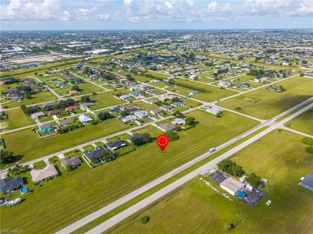 Aerial view of property and surrounding area featuring nearby suburban area