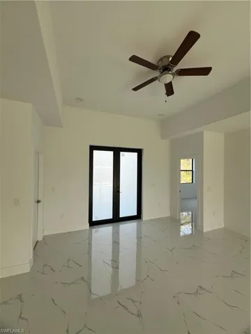 Spare room with marble finish floor, baseboards, and french doors