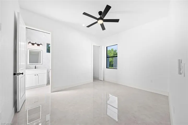 Polished tile flooring, modern ceiling fan, white paneled door, and recessed window