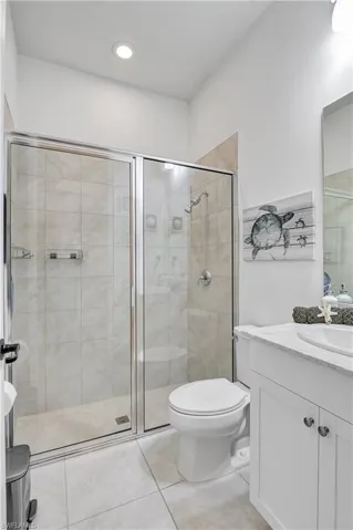 3rd full Bathroom for bedroom #2-featuring vanity, toilet, tile patterned floors, and a shower with shower door