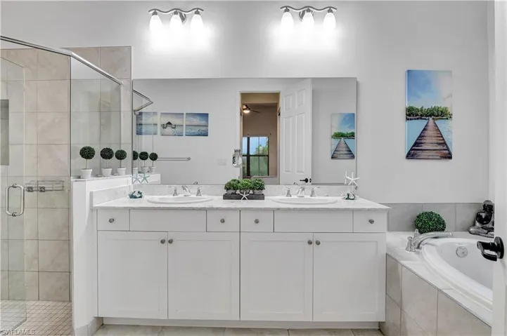 Primary Bathroom with vanity, plus walk in shower, and tile patterned floors