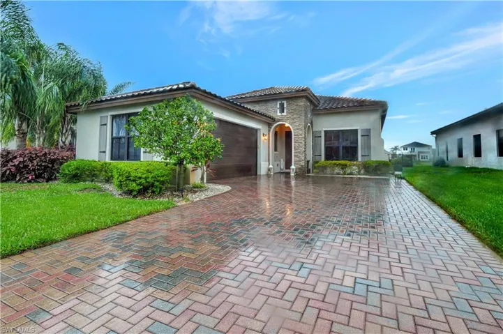 Mediterranean / spanish home featuring a garage and a front lawn