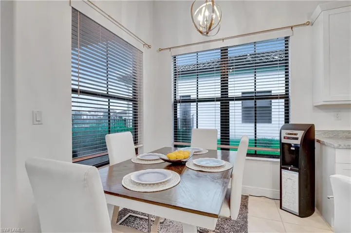 Tiled dining area featuring a notable chandelier