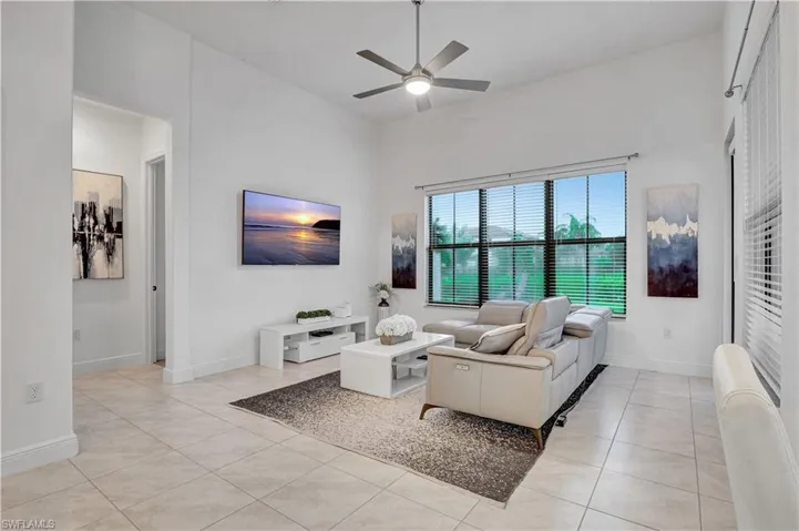 Living room with ceiling fan and light tile patterned floors