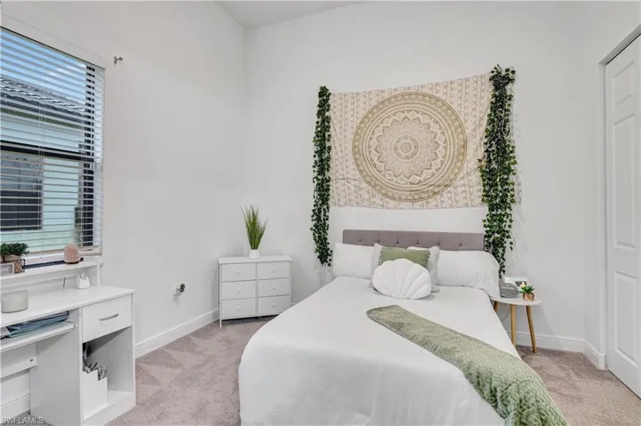 Bedroom 3 with light carpet vaulted ceilings and fan