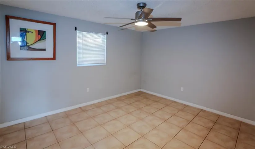 Tile flooring, neutral wall paint, and a ceiling fan with integrated lighting