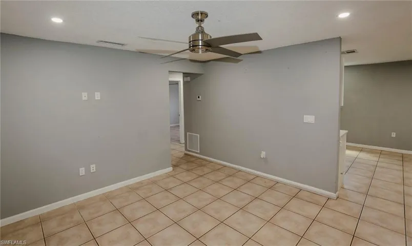Recessed lighting, ceiling fan, neutral wall paint, and tile flooring