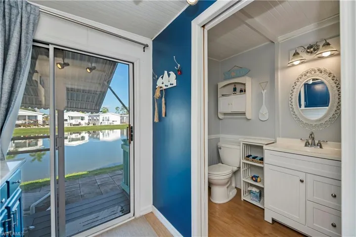 Bathroom with vanity, a water view, wood finished floors, and ornamental molding