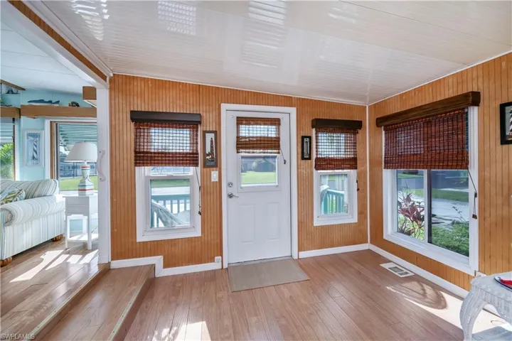 Foyer with wood finished floors, wood walls, and plenty of natural light
