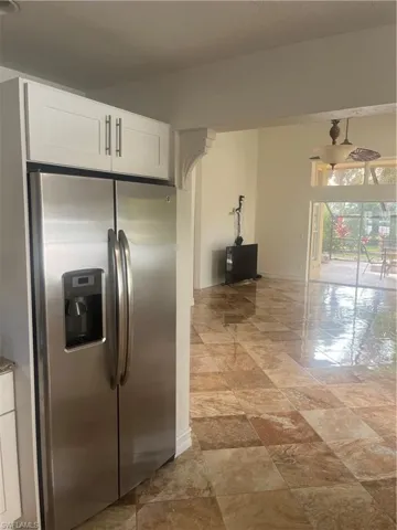 Kitchen featuring stainless steel refrigerator and white cabinets