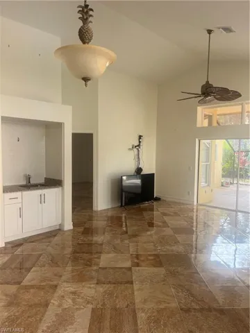 Unfurnished dining area with ceiling fan and high vaulted ceiling