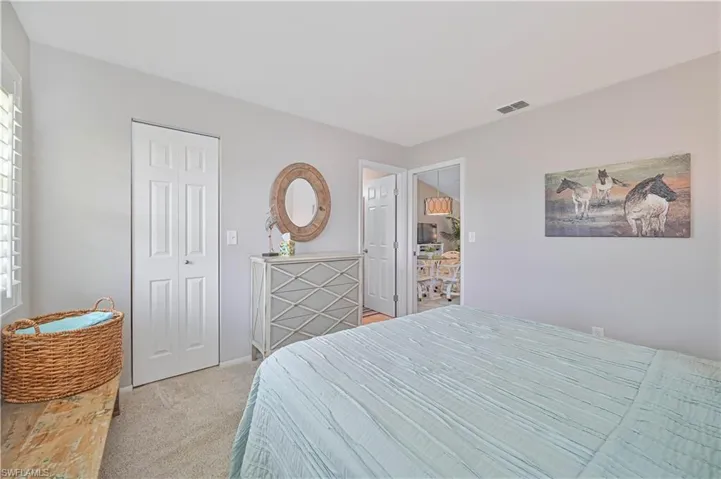 Bedroom featuring light carpet, a closet, baseboards, and visible vents