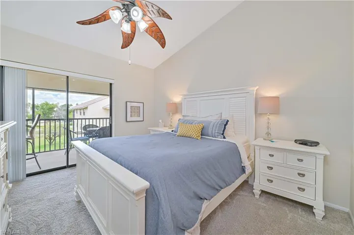 Bedroom featuring light colored carpet, access to outside, high vaulted ceiling, and a ceiling fan