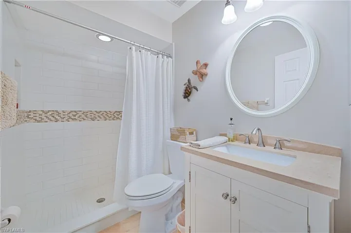 Full bath with a stall shower, vanity, and toilet