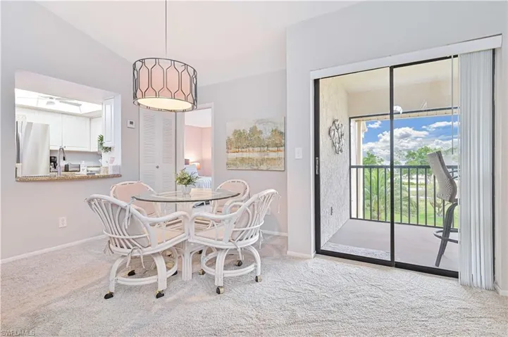 Dining space with vaulted ceiling, carpet floors, and baseboards