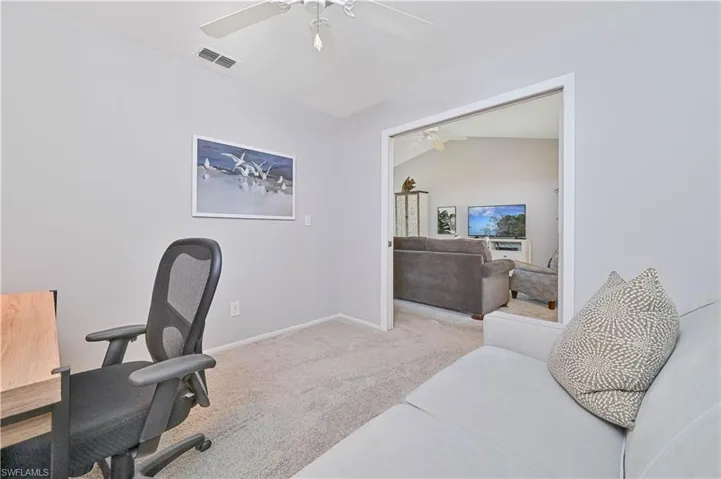 Carpeted office featuring baseboards, a ceiling fan, and visible vents