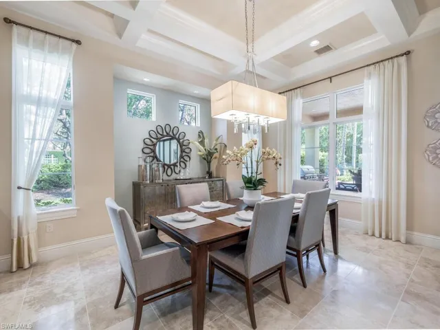 Dining area featuring niche for a sideboard, chandelier, and coffered ceiling