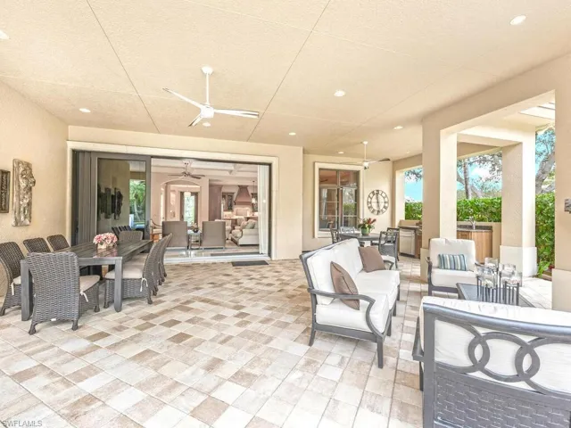 Dining area and outdoor living room under cover with a view of the pool