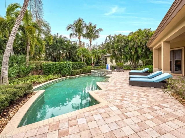 Landscaped backyard and fenced in pool with spa