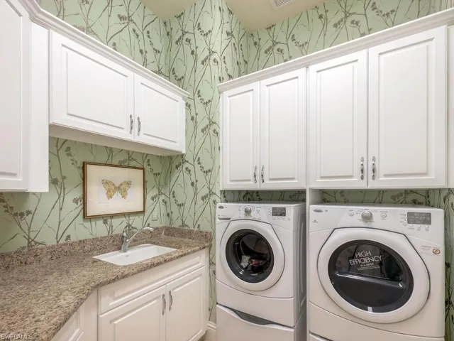 Laundry room on first floor with ample cabinets for storage