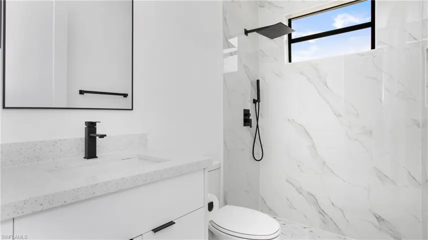 Full bathroom with vanity and a marble finish shower